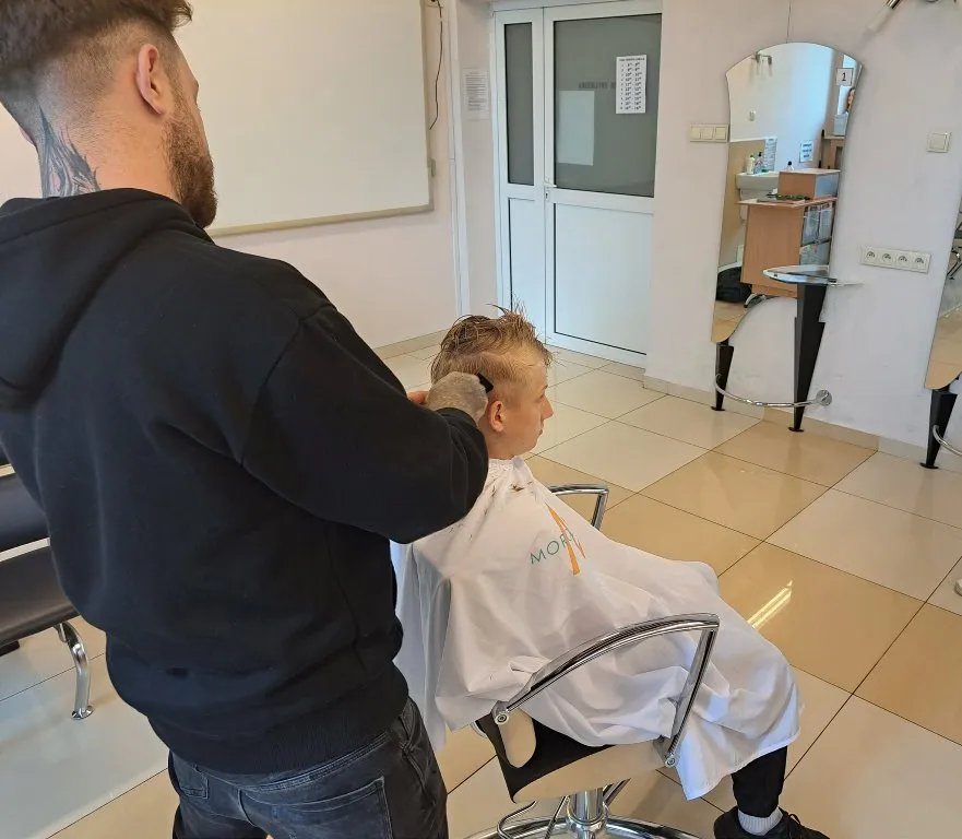 Uczniowie na pokazie strzyżenia męskiego