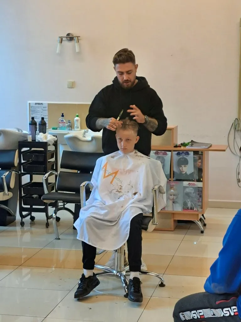 Uczniowie na pokazie strzyżenia męskiego